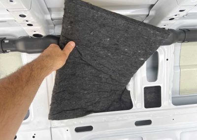 Installer positioning AutoPly wall insulation panel inside Mercedes-Benz Sprinter 170 cargo van interior